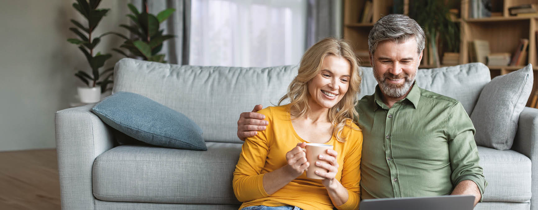 A man and woman sitting on a couch, both holding cell phones. Description generated by AI