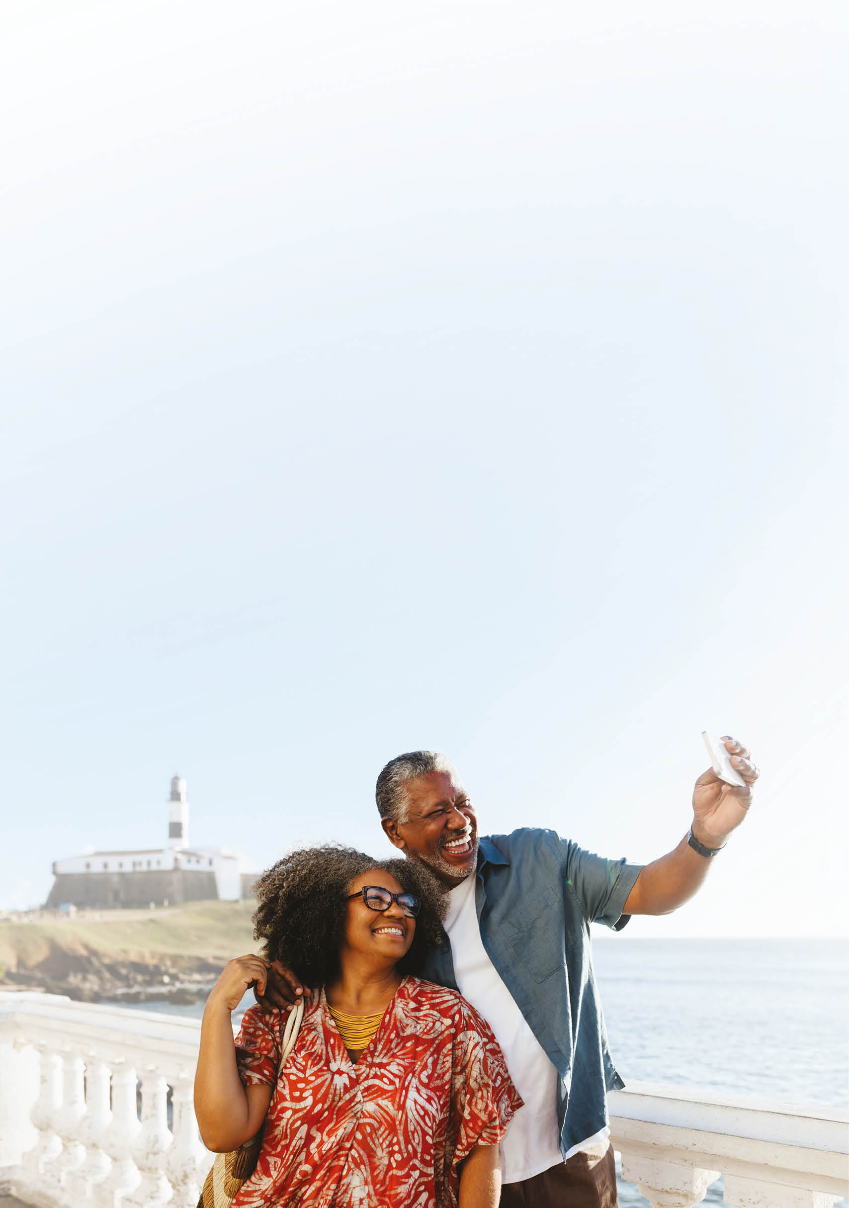 A man and woman standing on a pier taking a selfie. Description generated by AI