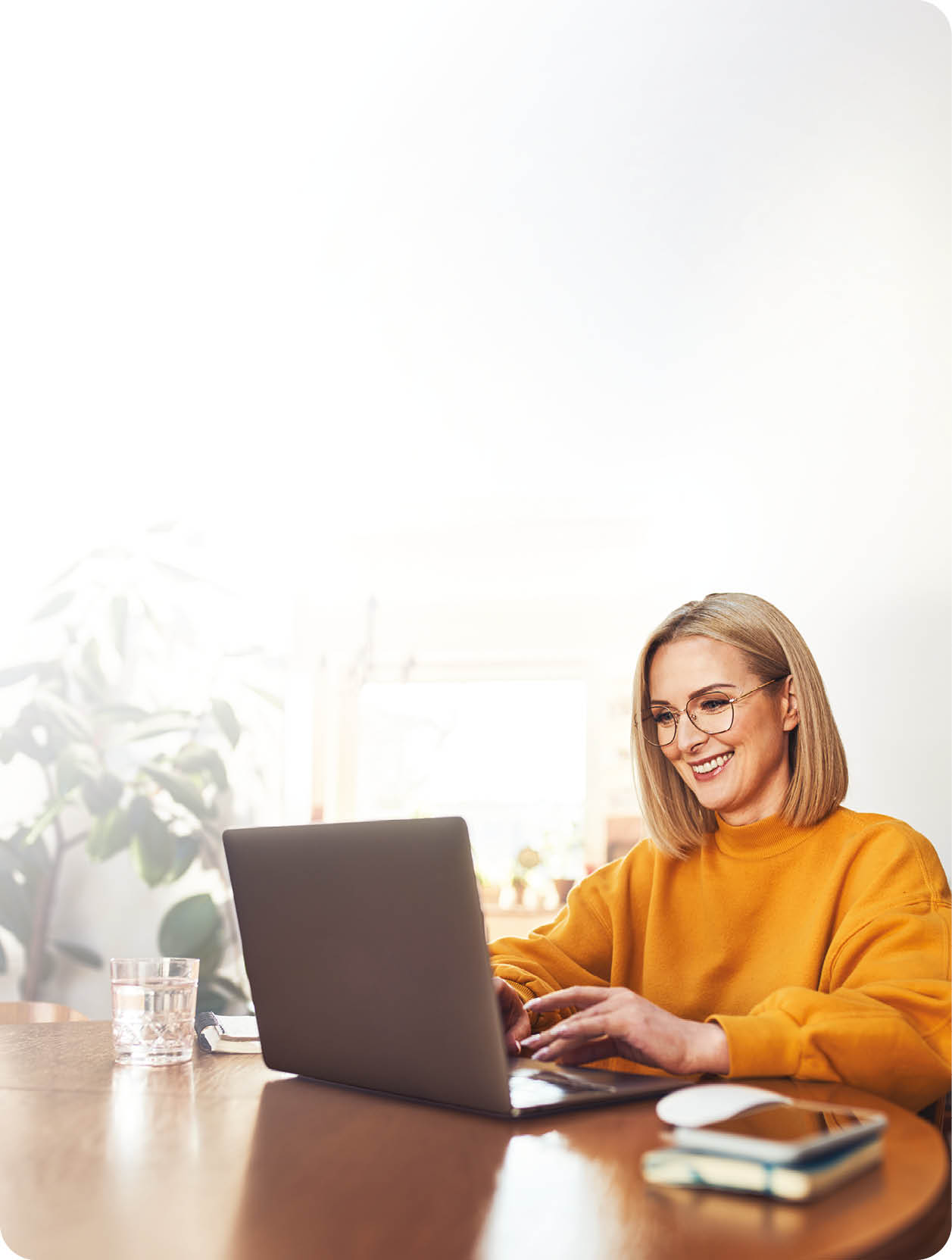 A woman is sitting at a desk using a laptop. Description generated by AI
