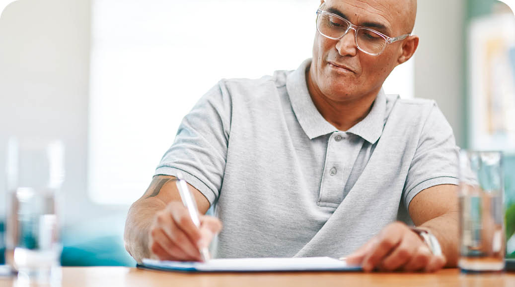 Home, documents and man writing, planning and life insurance with mortgage, update will and testament. Apartment, person or guy with paperwork, budget and retirement fund with schedule or information