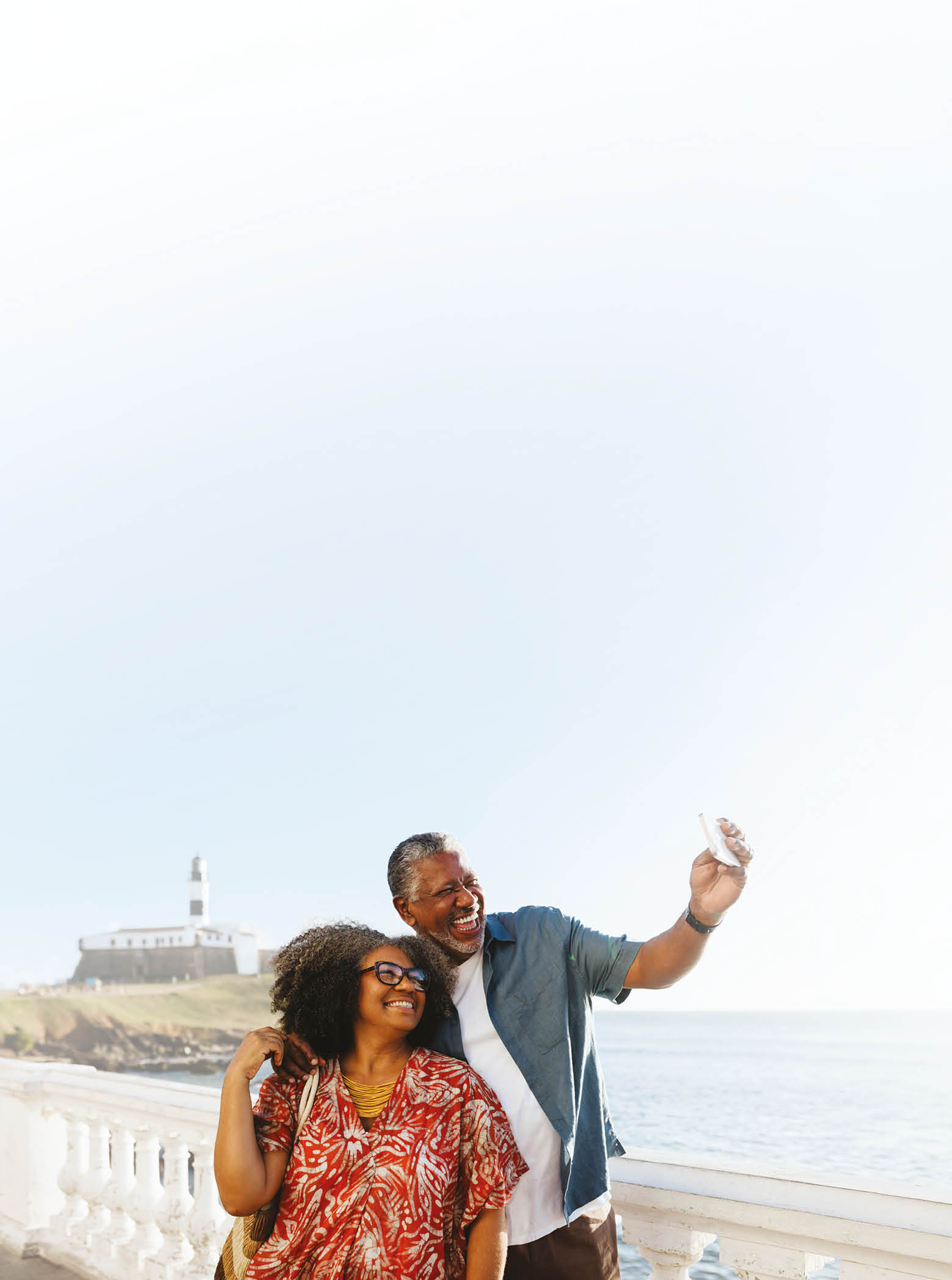 A man and woman standing on a pier taking a selfie. Description generated by AI