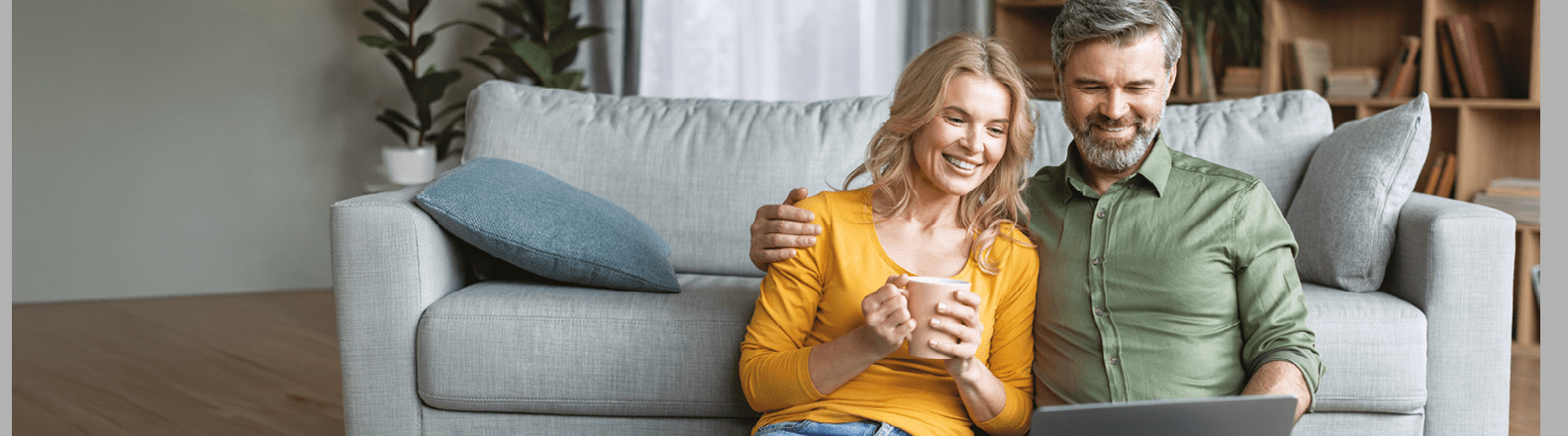 A man and woman sitting on a couch, both holding cell phones. Description generated by AI