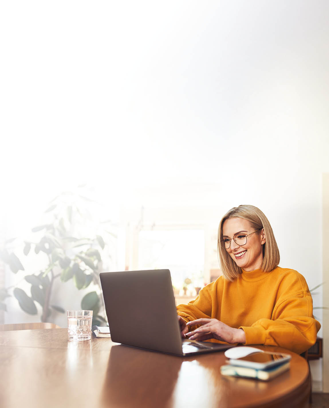 A woman is sitting at a desk using a laptop. Description generated by AI