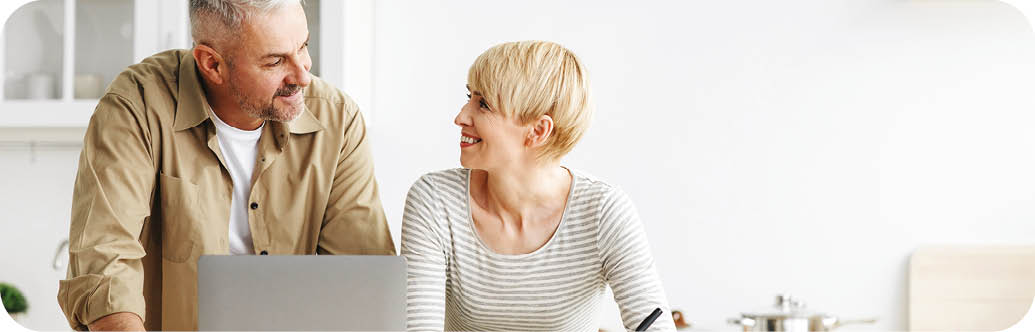 A man and woman are sitting at a kitchen counter. Description generated by AI