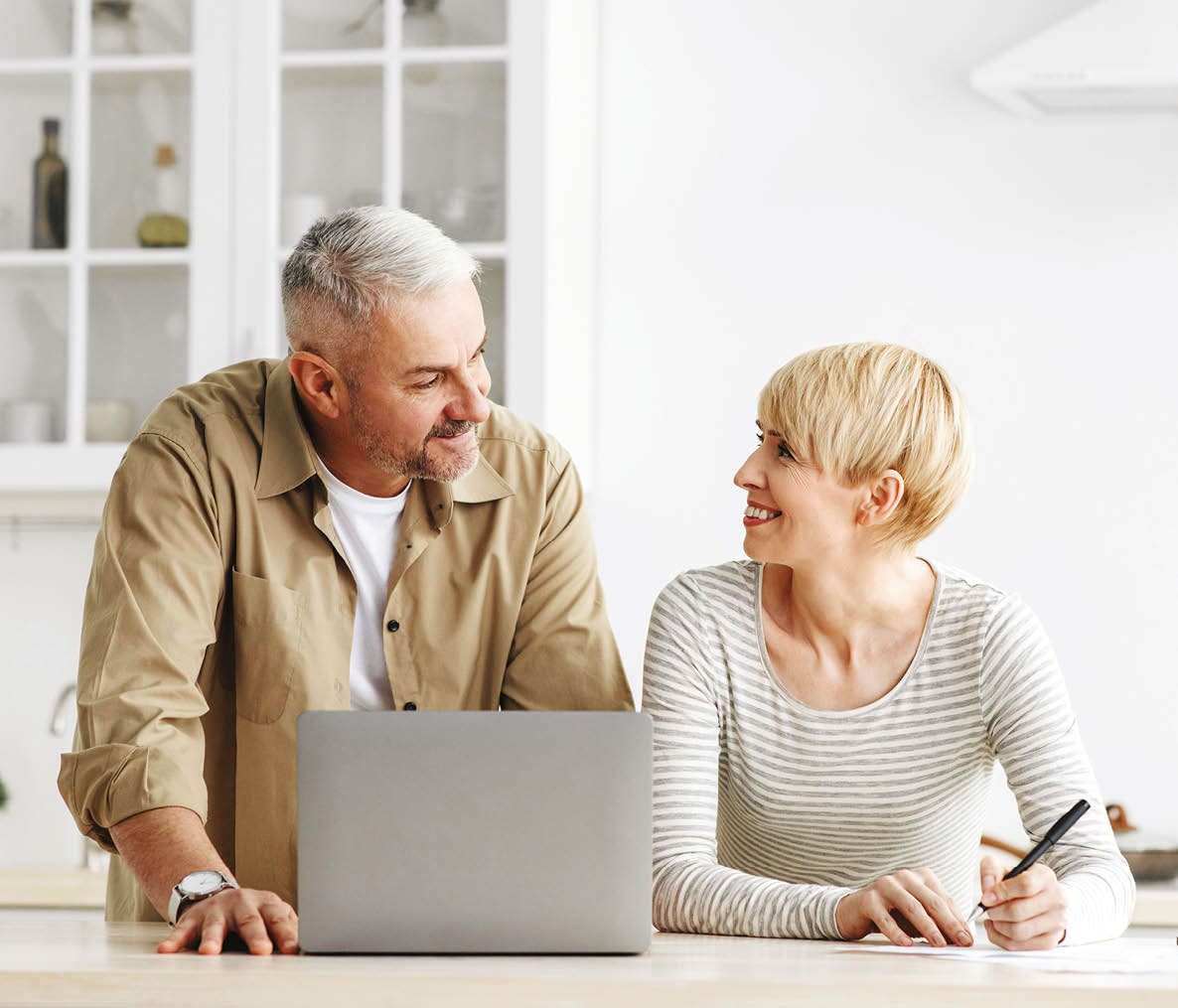 A man and woman are sitting at a kitchen counter. Description generated by AI