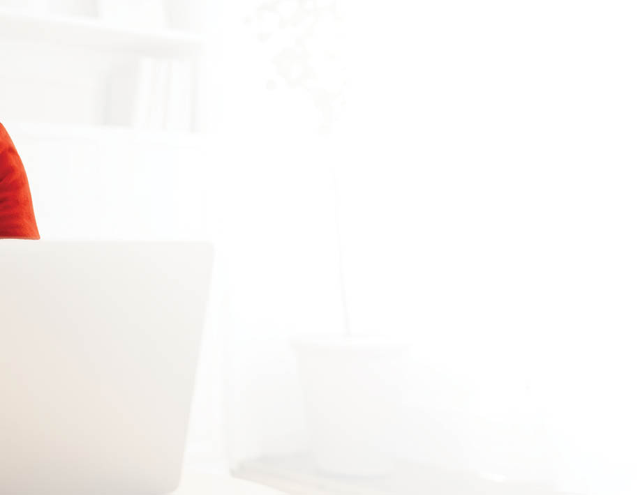 Mature man sitting on sofa at home and using laptop for work.