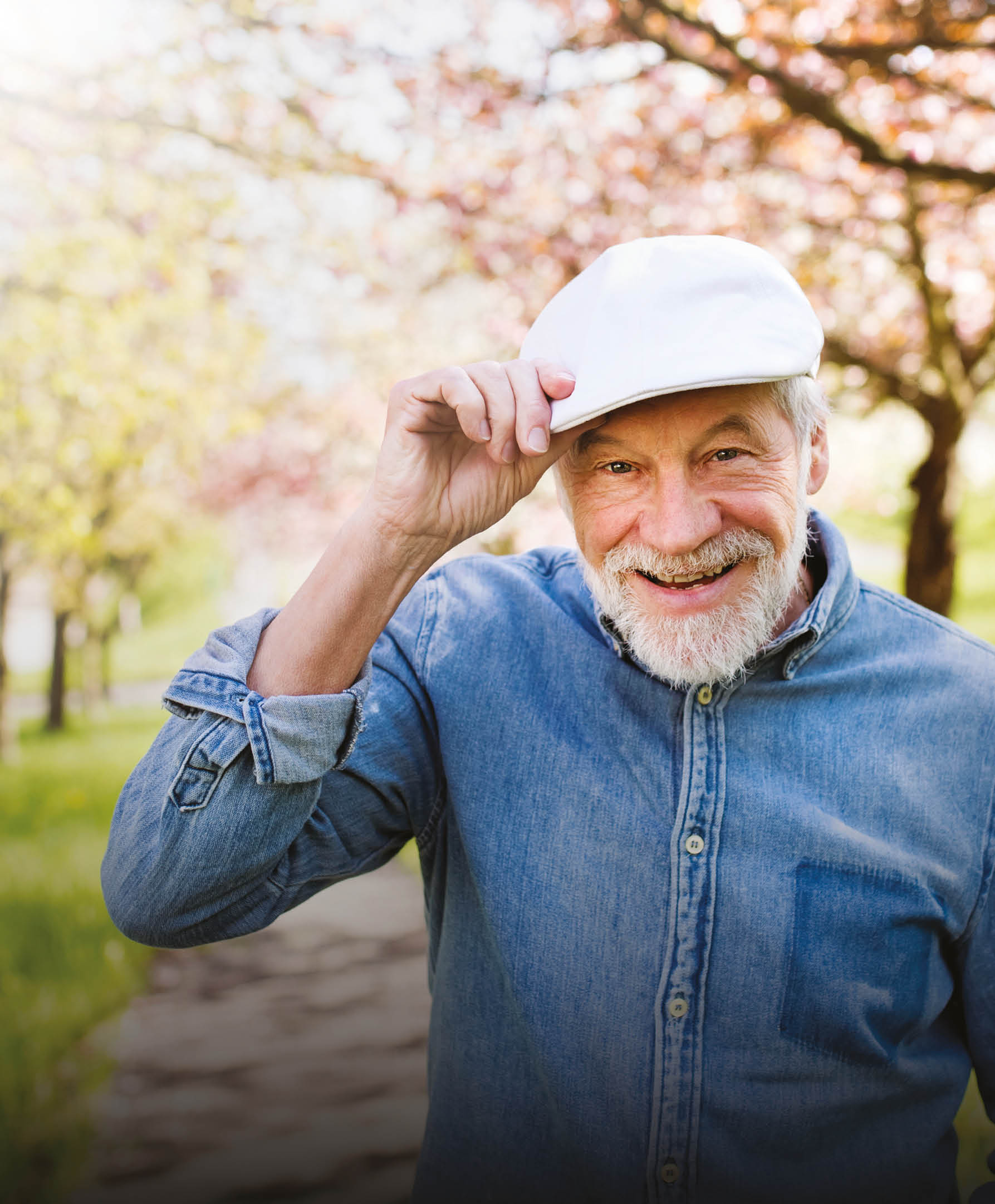 A man wearing a hat and blue shirt is standing in a park with trees in the background. AI generated content