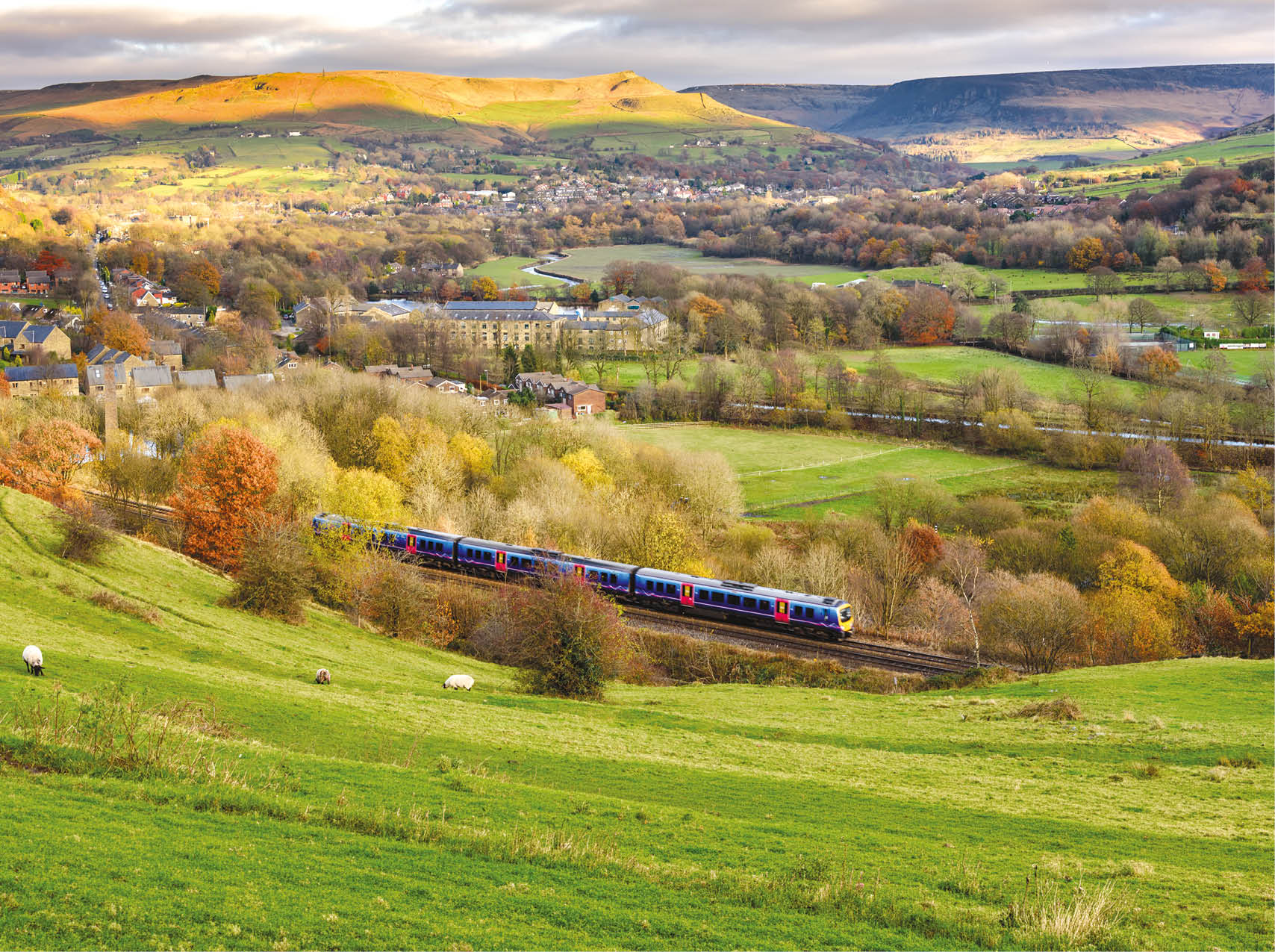 A train is traveling through a rural countryside, passing by a small town and a lush green hillside. AI generated content