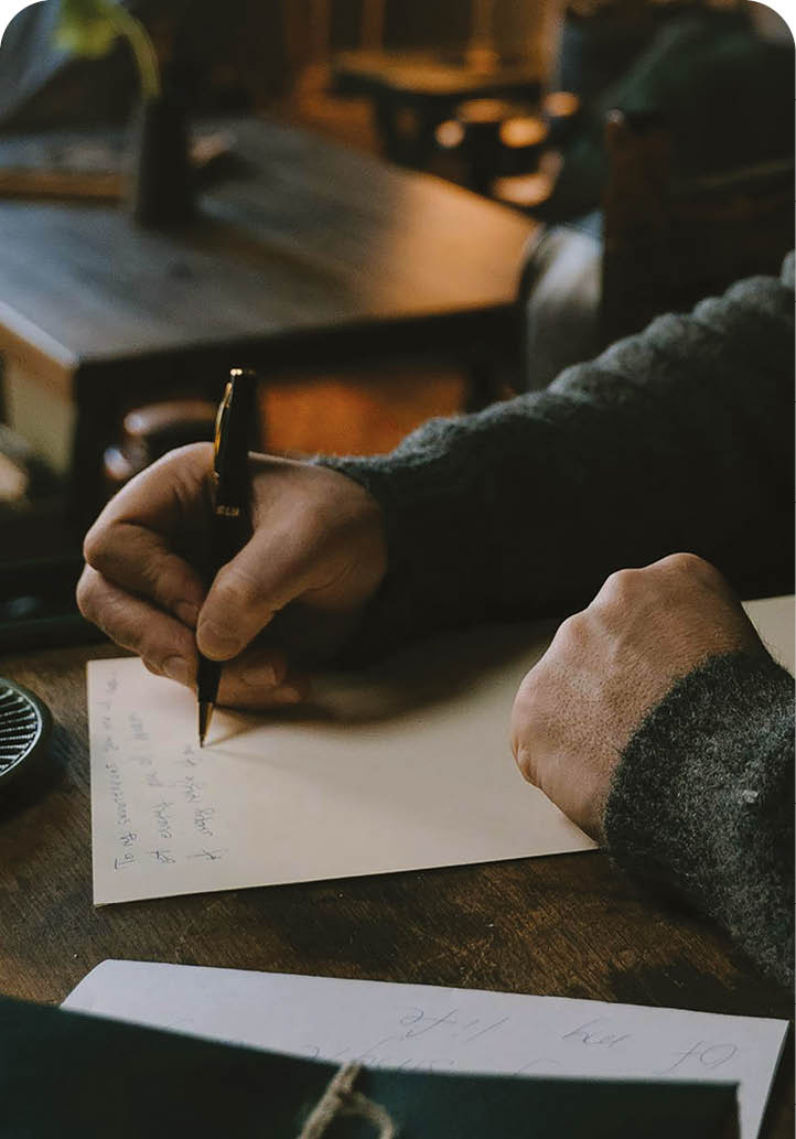 A man is sitting at a desk writing in a book. AI generated content