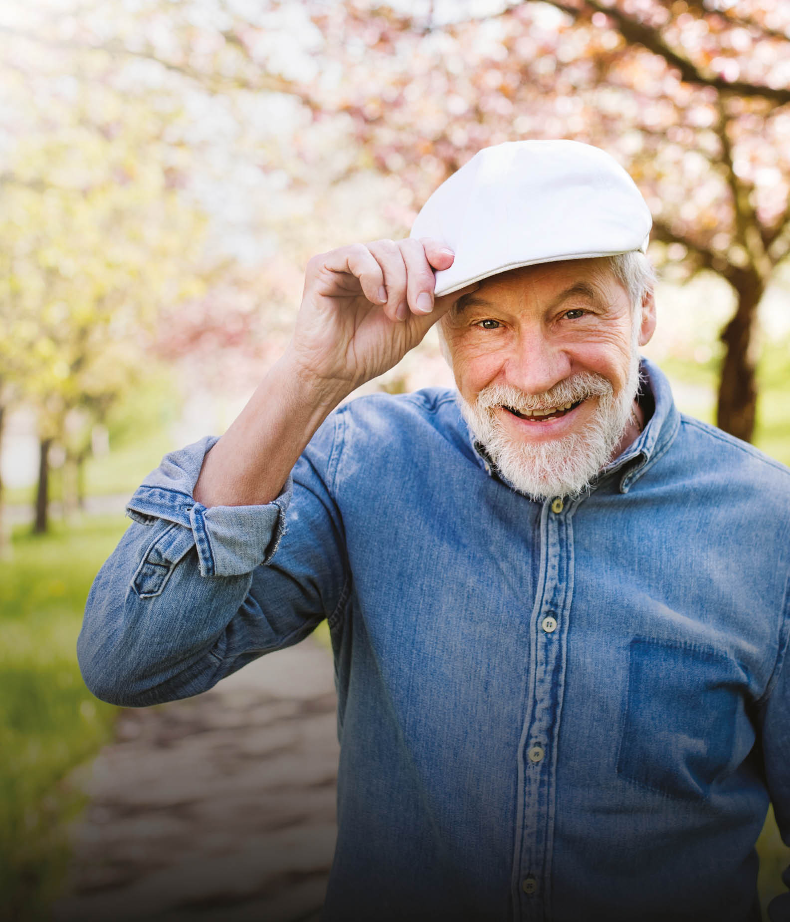 A man wearing a hat and blue shirt is standing in a park with trees in the background. AI generated content