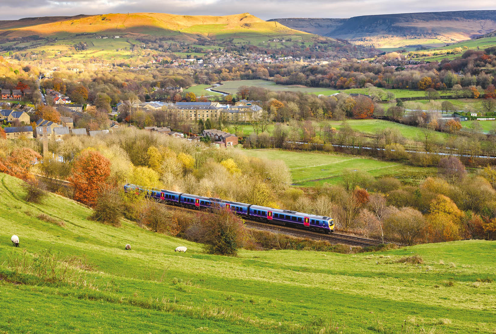 A train is traveling through a rural countryside, passing by a small town and a lush green hillside. AI generated content