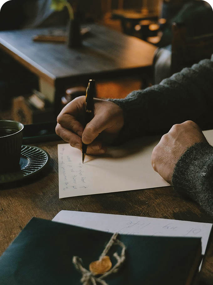 A man is sitting at a desk writing in a book. AI generated content