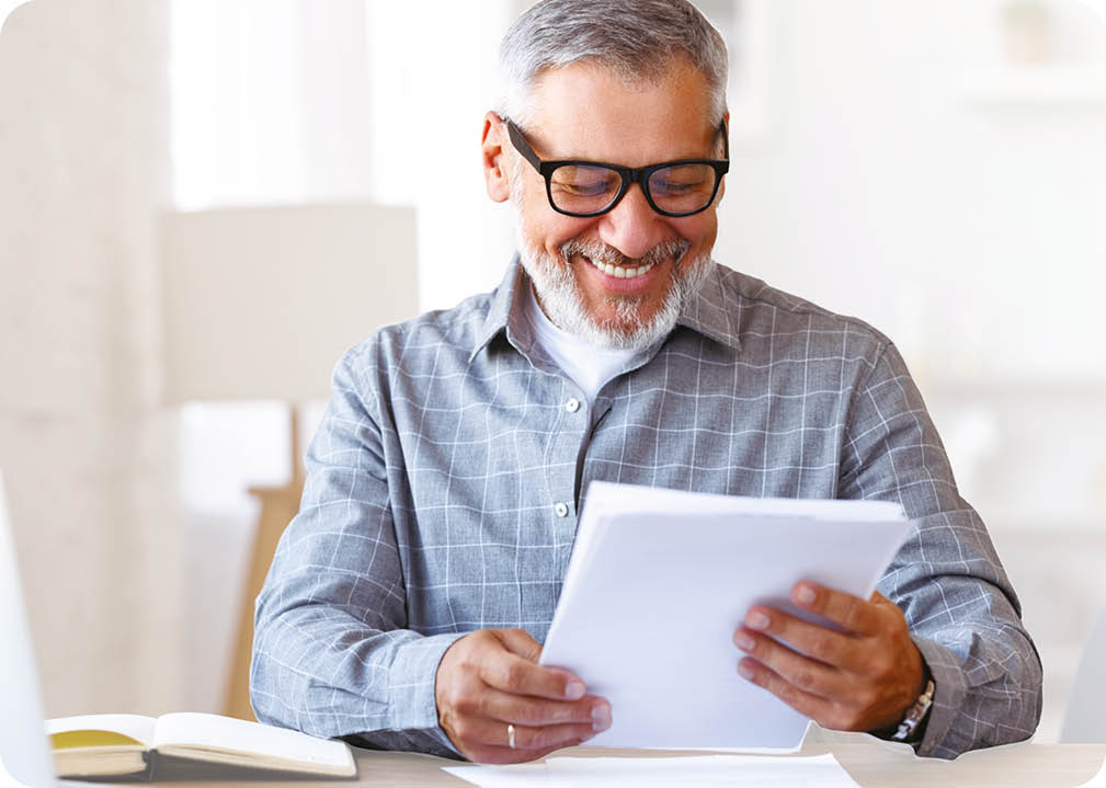 A man is sitting at a desk with a laptop and a book in front of him. AI generated content