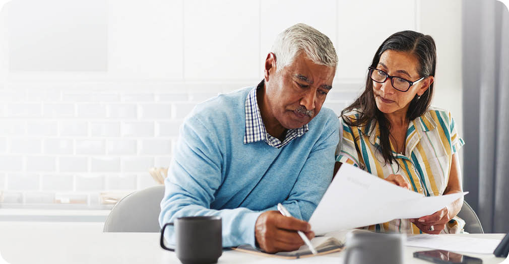A man and woman are sitting at a table, looking at a cell phone. AI generated content