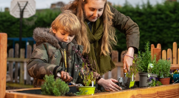 A woman and young child planting in the garden. Image by Matthew Power Photography.