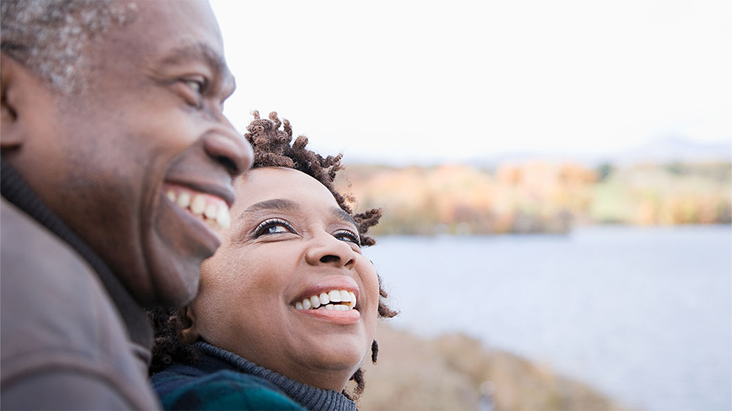 A couple smiling while enjoying a beach view