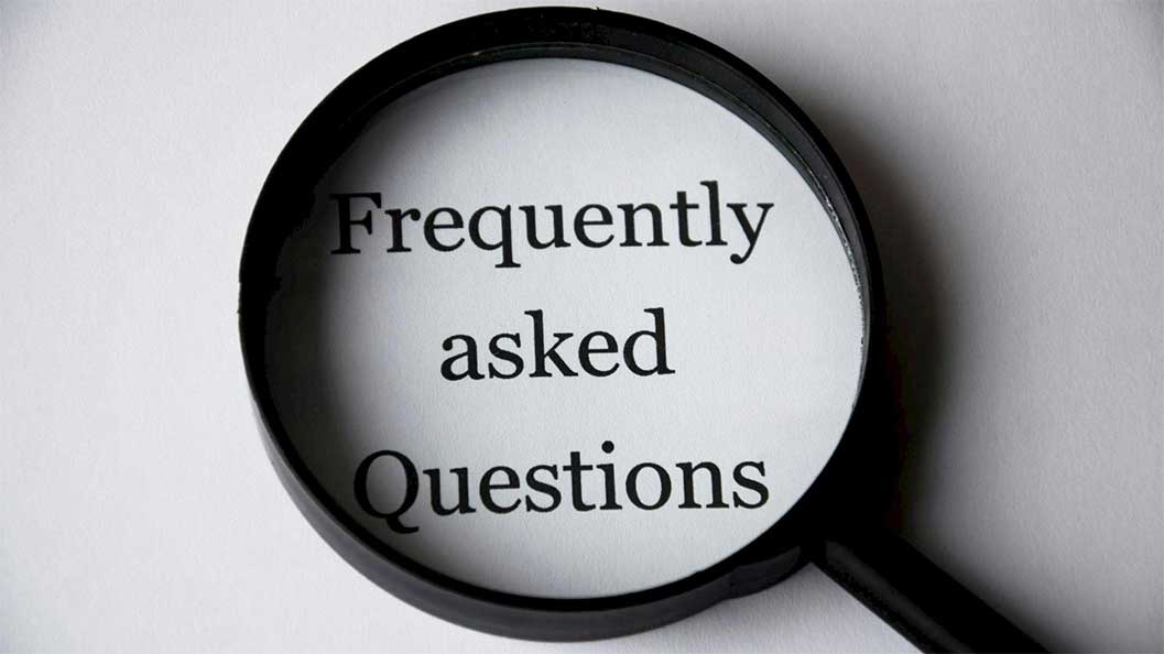 A magnifying glass put over a frequently asked questions sign