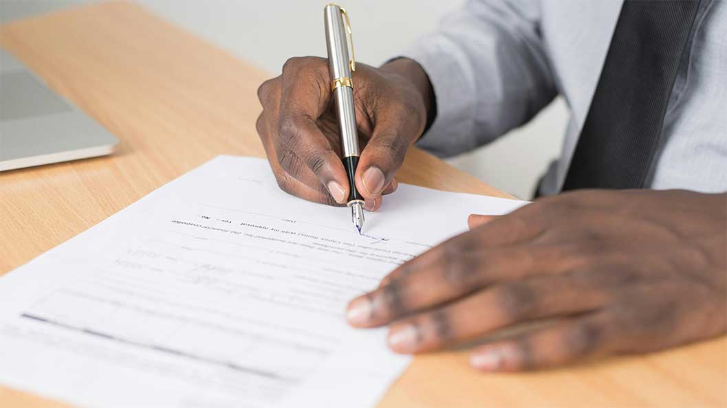 Male hands signing some paperwork