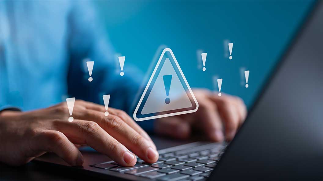 Male hands typing on a laptop keyboard and an attention sign
